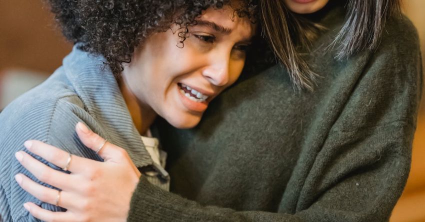 Empathy - Young unhappy woman crying and hugging empathetic female friend