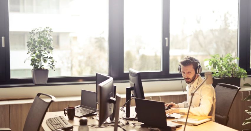 Service - Man With Headphones Facing Computer Monitor